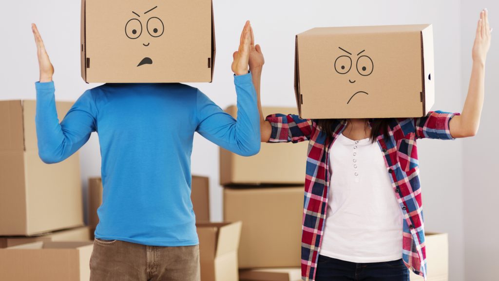 couple with moving boxes on their heads unhappy