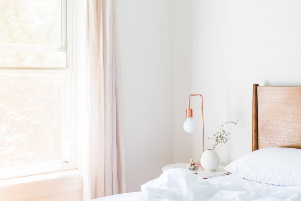 lamp on a side table in a white bedroom