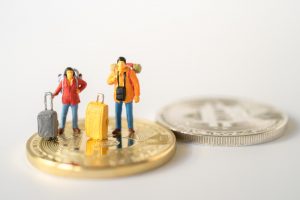 Two figures with suitcases on coin